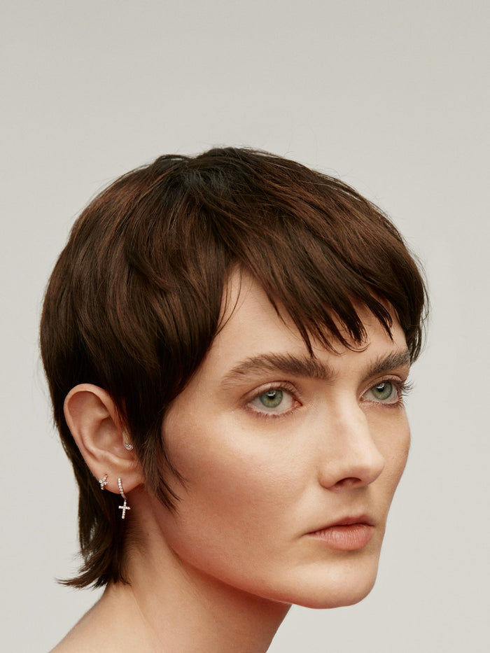 Pendiente individual de oro blanco de 18K con diamantes y cruz