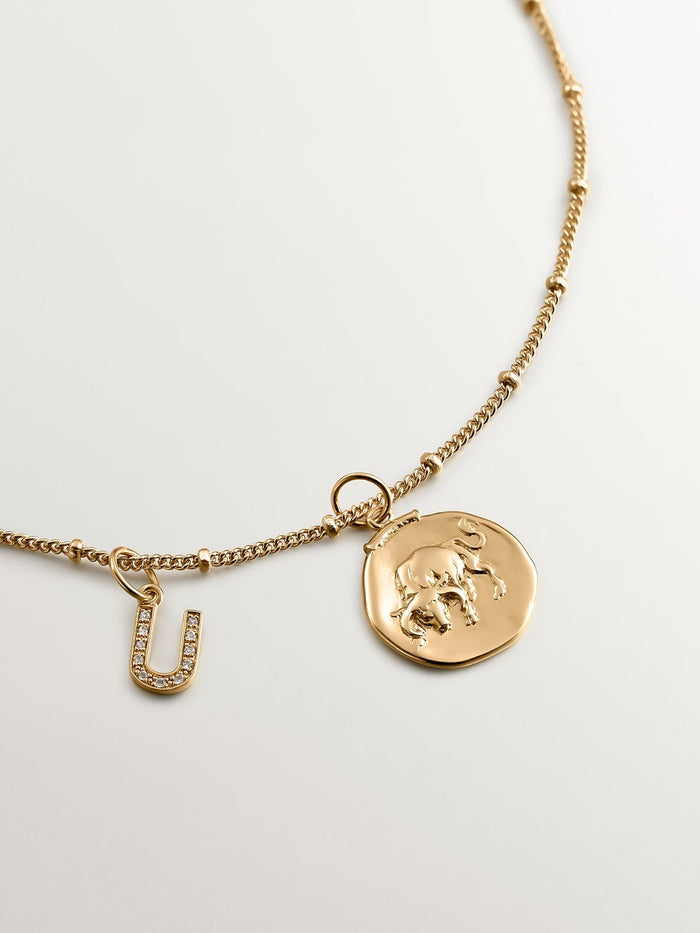 Charm de plata 925 bañada en oro amarillo de 18K y topacios blancos inicial U