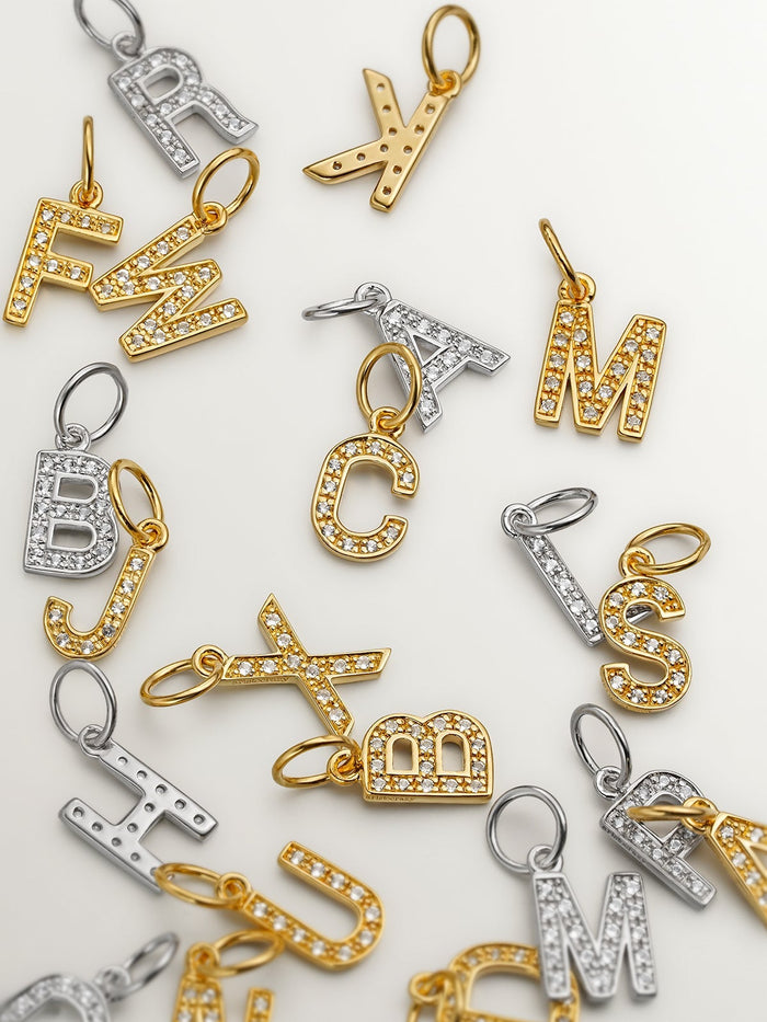 Charm de plata 925 bañada en oro amarillo de 18K y topacios blancos inicial U