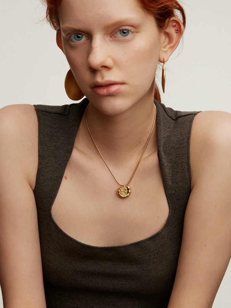Charm caracola de plata bañada en oro amarillo de 18kt con esmalte azul y piedras topacios blancos