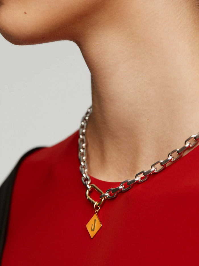 Charm de plata 925 bañada en oro amarillo de 18K con inicial J y esmalte naranja con forma de rombo