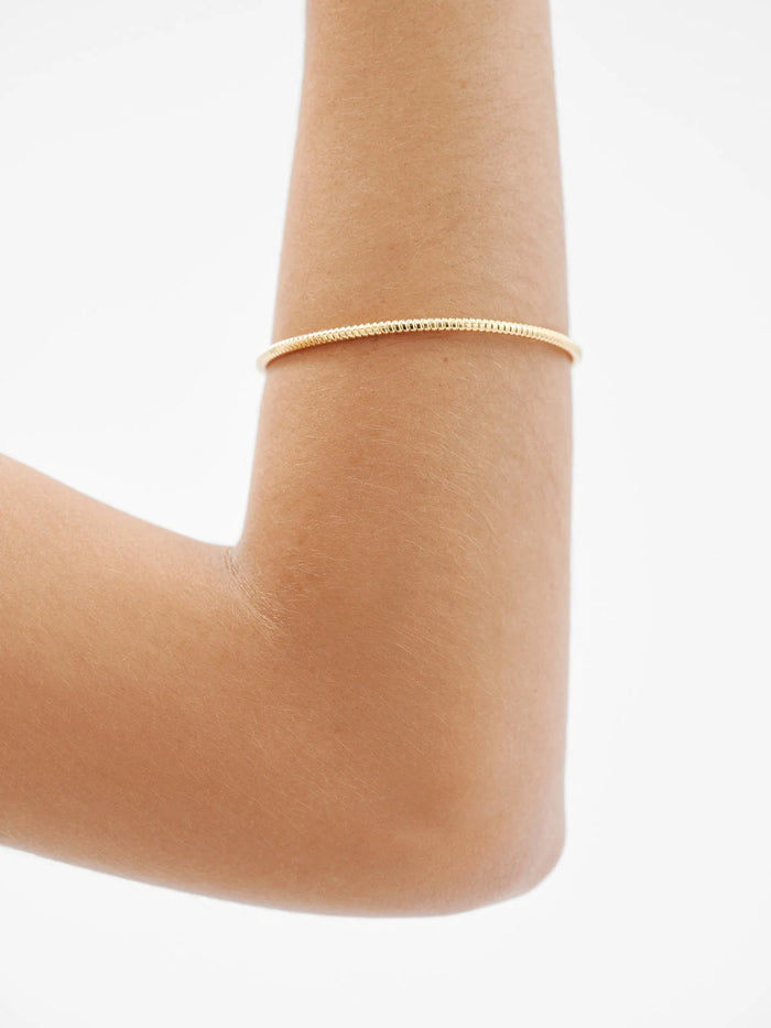 Pulsera rígida estilo semanario de plata 925 bañada en oro amarillo de 18K.